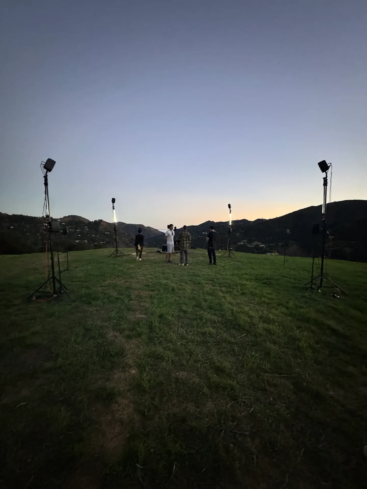 Circular speaker deployment on individual stands in an outdoor environment. Lighting added solely for spatial visibility.